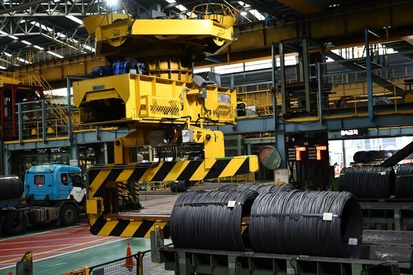 크레인이 선재 코일의 중심점 위치를 추적해 제품 야드에서 제품을 들어올리고 있다. [사진=포스코]" height="400" loading="lazy